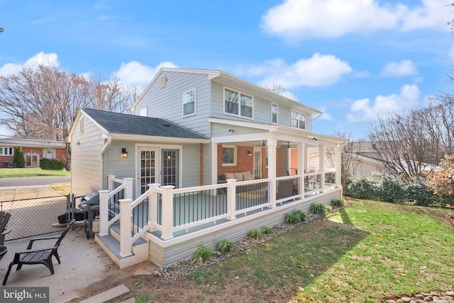 rear view of house with a patio, a yard, fence, and a sunroom