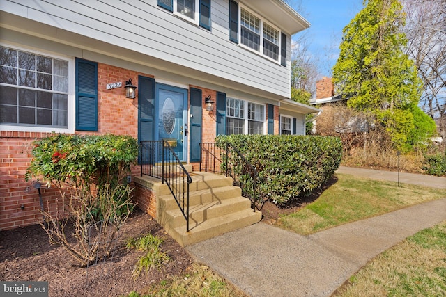 view of exterior entry with brick siding