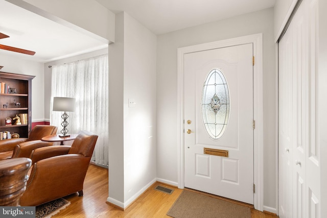 foyer entrance with light wood-style flooring, baseboards, a healthy amount of sunlight, and ceiling fan