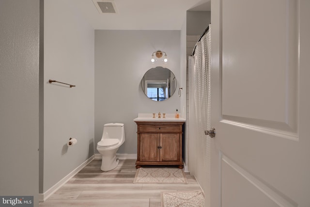 bathroom with vanity, wood-type flooring, and toilet