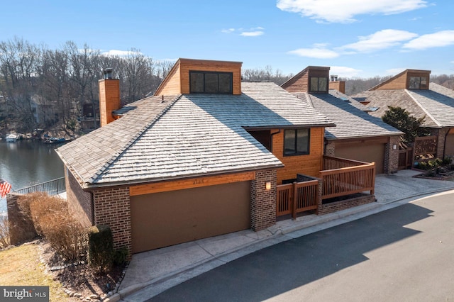 view of front of property with a garage and a water view