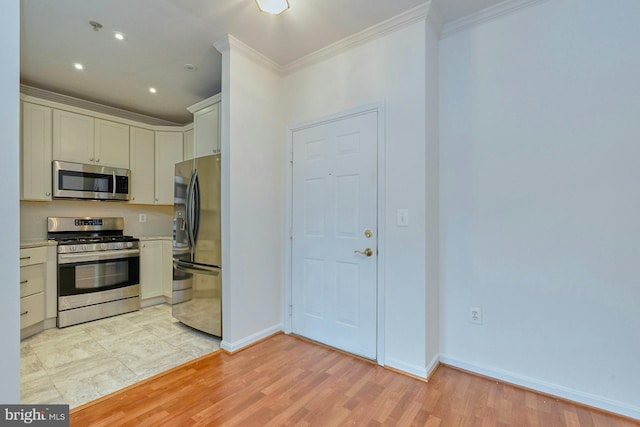 kitchen with stainless steel appliances, light countertops, crown molding, and light wood-style flooring