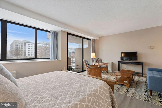 bedroom with hardwood / wood-style floors and a textured ceiling