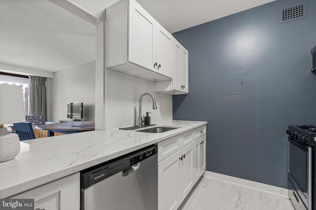 kitchen featuring white cabinetry, appliances with stainless steel finishes, light stone countertops, and sink