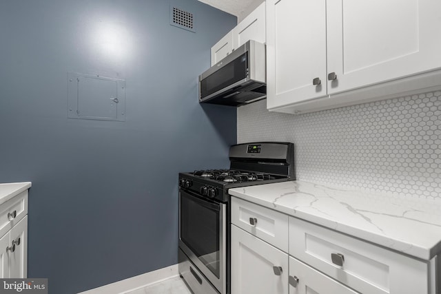 kitchen featuring appliances with stainless steel finishes, white cabinetry, backsplash, electric panel, and light stone countertops