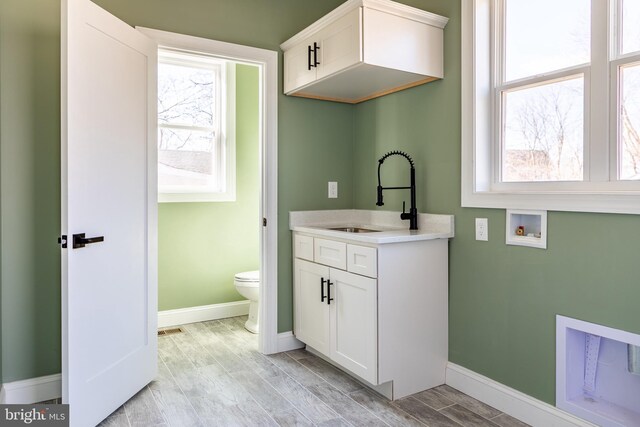 bathroom with visible vents, baseboards, toilet, vanity, and wood finish floors