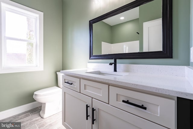 full bathroom featuring baseboards, a shower, toilet, wood tiled floor, and vanity