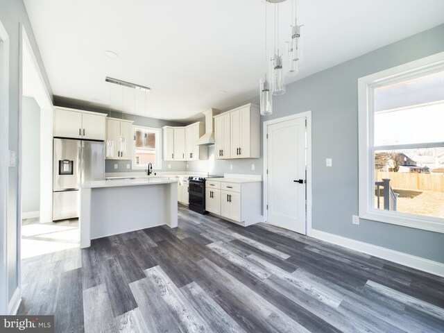 kitchen featuring stainless steel refrigerator with ice dispenser, light countertops, and decorative light fixtures