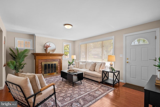 living room featuring baseboards, a fireplace, and wood finished floors