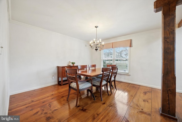 dining room featuring crown molding, an inviting chandelier, and hardwood / wood-style floors