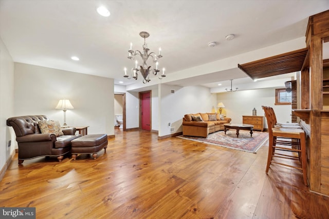 living room with an inviting chandelier and hardwood / wood-style flooring