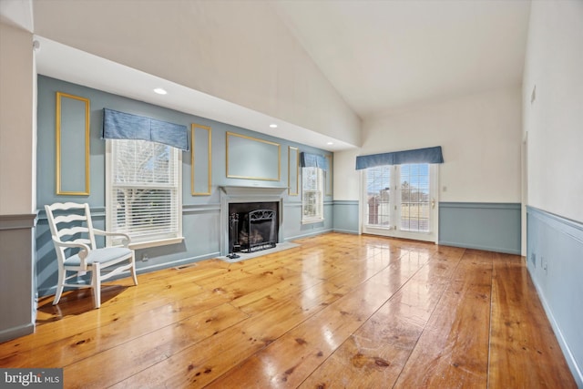 unfurnished living room with high vaulted ceiling and hardwood / wood-style floors