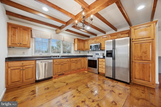 kitchen featuring sink, light hardwood / wood-style floors, beamed ceiling, and appliances with stainless steel finishes