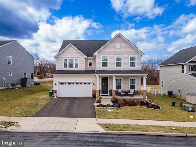 view of front of home with a garage, covered porch, central AC, and a front lawn