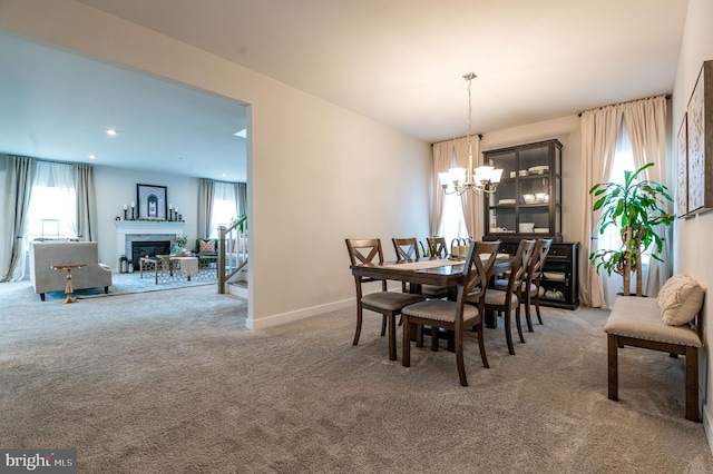 carpeted dining space with a chandelier