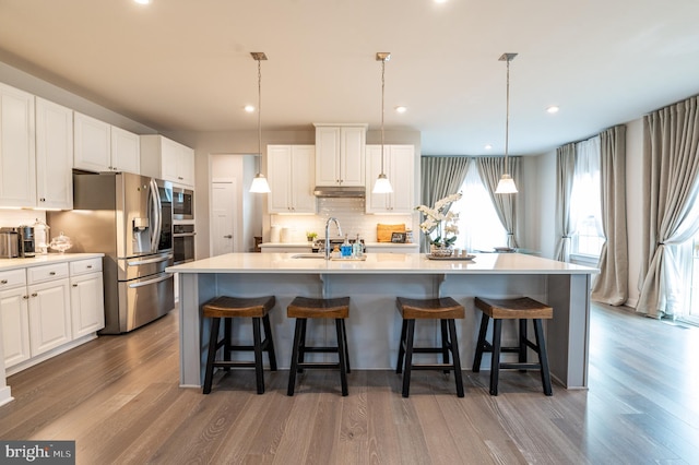 kitchen with a spacious island, appliances with stainless steel finishes, and white cabinets