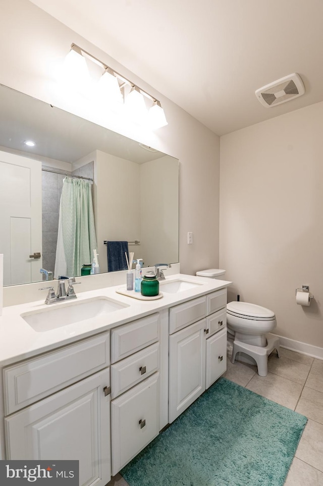 bathroom featuring toilet, tile patterned flooring, vanity, and walk in shower