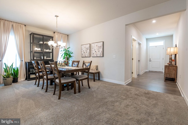 carpeted dining space featuring an inviting chandelier