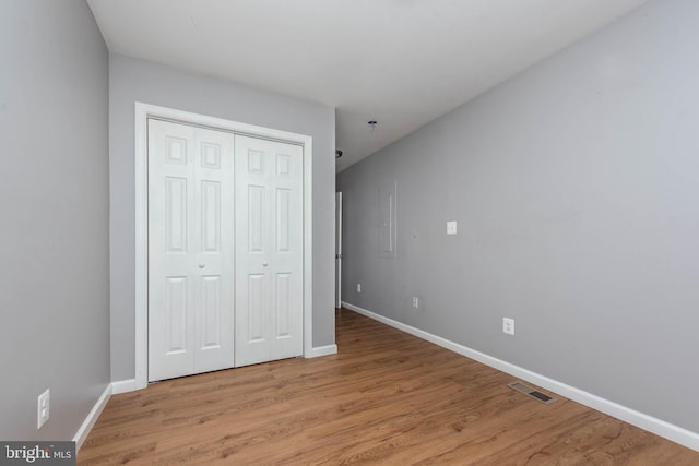 unfurnished bedroom featuring light hardwood / wood-style floors and a closet