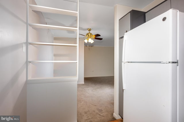 interior space featuring a ceiling fan, freestanding refrigerator, and light colored carpet