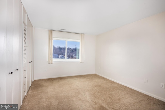 unfurnished bedroom with light colored carpet, visible vents, and baseboards