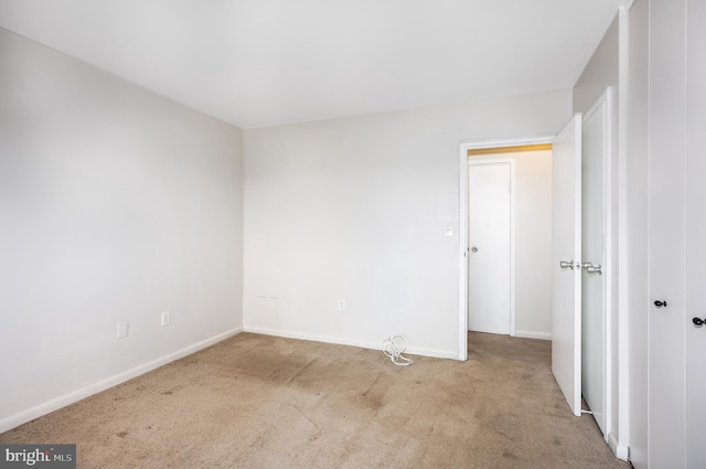 empty room with light carpet and baseboards