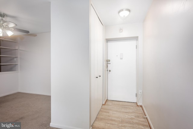 hall with light colored carpet and baseboards