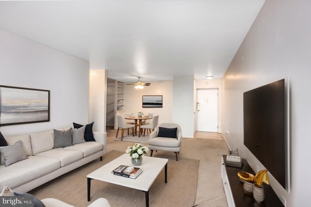 living area with light carpet and a ceiling fan