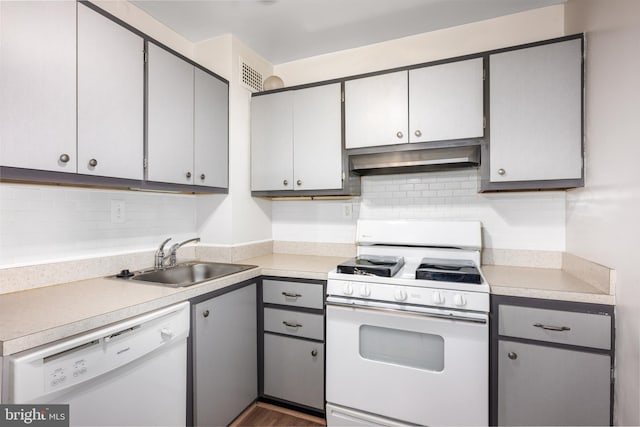 kitchen with light countertops, gray cabinetry, a sink, white appliances, and under cabinet range hood