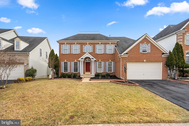 view of front of home with driveway, a front lawn, and brick siding