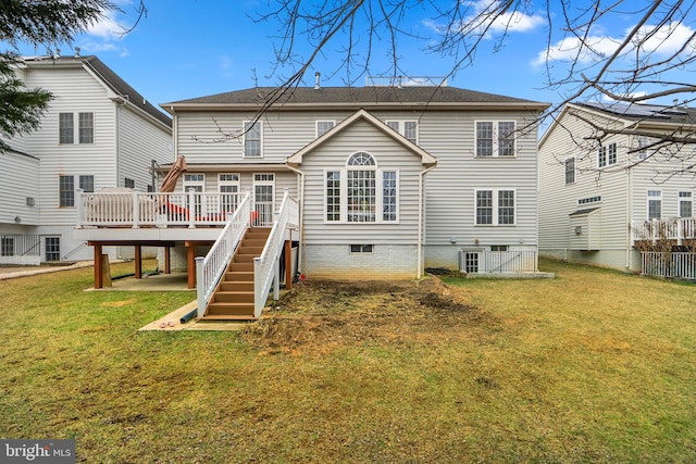 rear view of house with a lawn, stairway, and a wooden deck