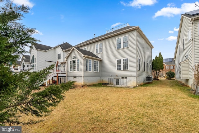 rear view of property featuring a lawn