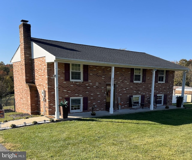 split foyer home featuring a front yard and a patio