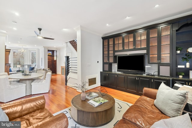 living room with ceiling fan, ornamental molding, and light hardwood / wood-style floors