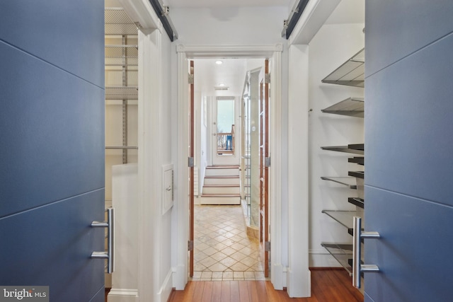 corridor with hardwood / wood-style floors and a barn door