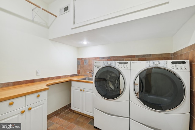 laundry area featuring sink, cabinets, and independent washer and dryer