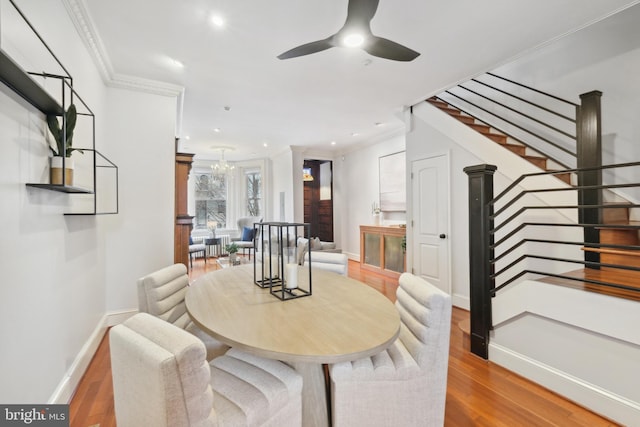 dining area featuring hardwood / wood-style floors, crown molding, and ceiling fan with notable chandelier