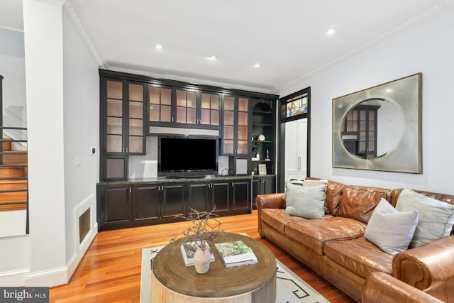 living room featuring light hardwood / wood-style floors and crown molding