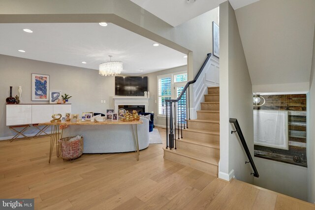 living room with an inviting chandelier and light hardwood / wood-style flooring