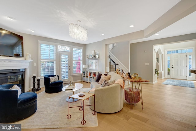 living room with light hardwood / wood-style floors and a chandelier