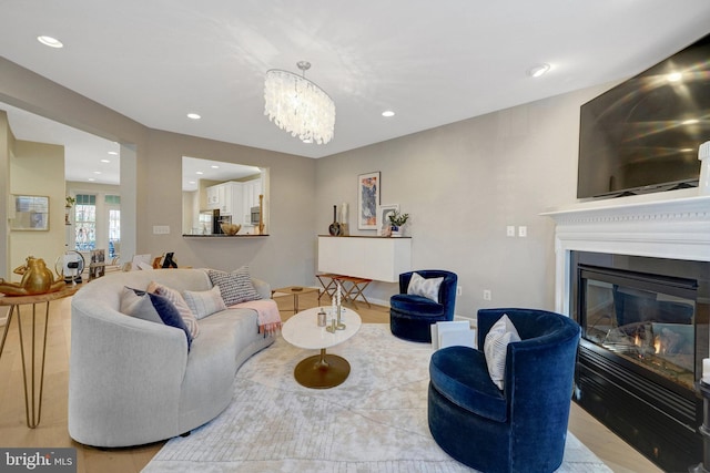 living room with light hardwood / wood-style floors and a notable chandelier