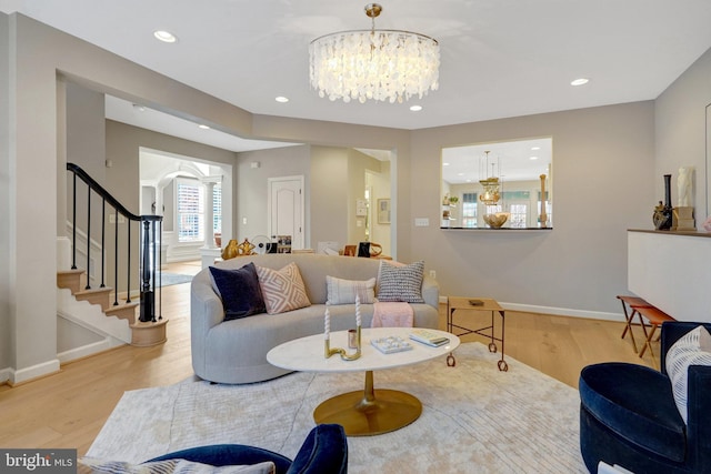 living room with light wood-type flooring and a notable chandelier