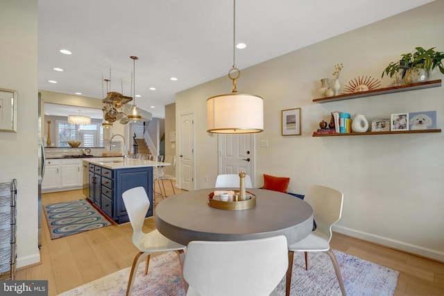 dining space with sink and light wood-type flooring