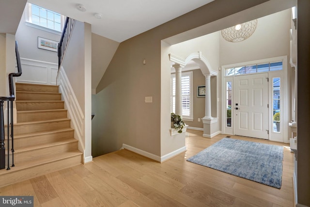 foyer with light wood-type flooring and decorative columns