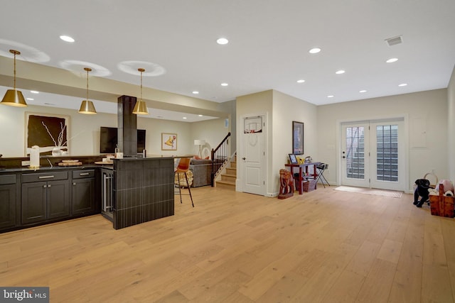 kitchen with light hardwood / wood-style flooring, a breakfast bar area, and decorative light fixtures