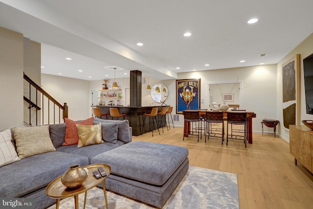 living room with light hardwood / wood-style flooring and bar