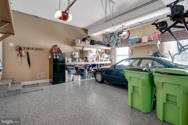 garage with black fridge and a garage door opener