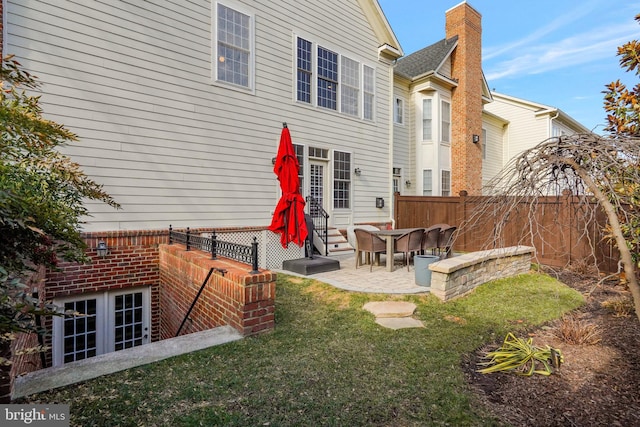 back of property featuring a patio area and a lawn