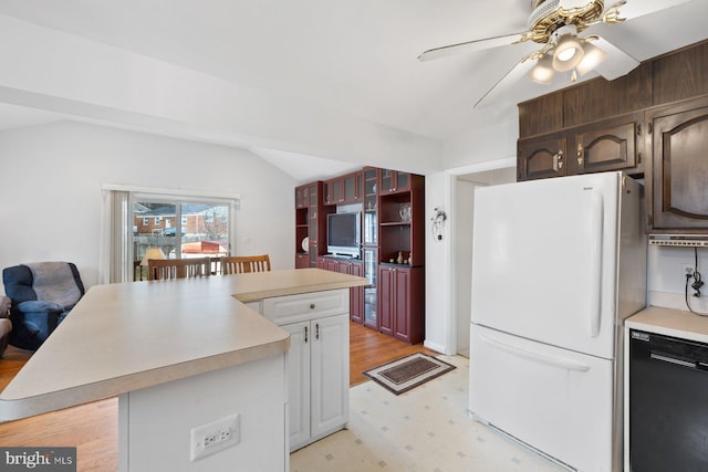 kitchen with dishwasher, lofted ceiling, a breakfast bar area, white fridge, and dark brown cabinetry