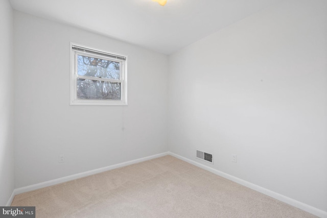 spare room featuring light colored carpet